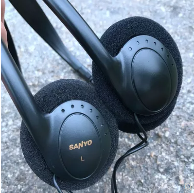 The old man wears headphones retro Sanyo with the same headset CD with headphones